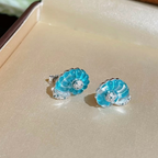 Rhodium-plated sterling silver nautilus shell stud earrings with blue cubic zirconia and clear pavé accents