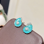 Rhodium-plated sterling silver nautilus shell stud earrings with blue cubic zirconia and clear pavé accents