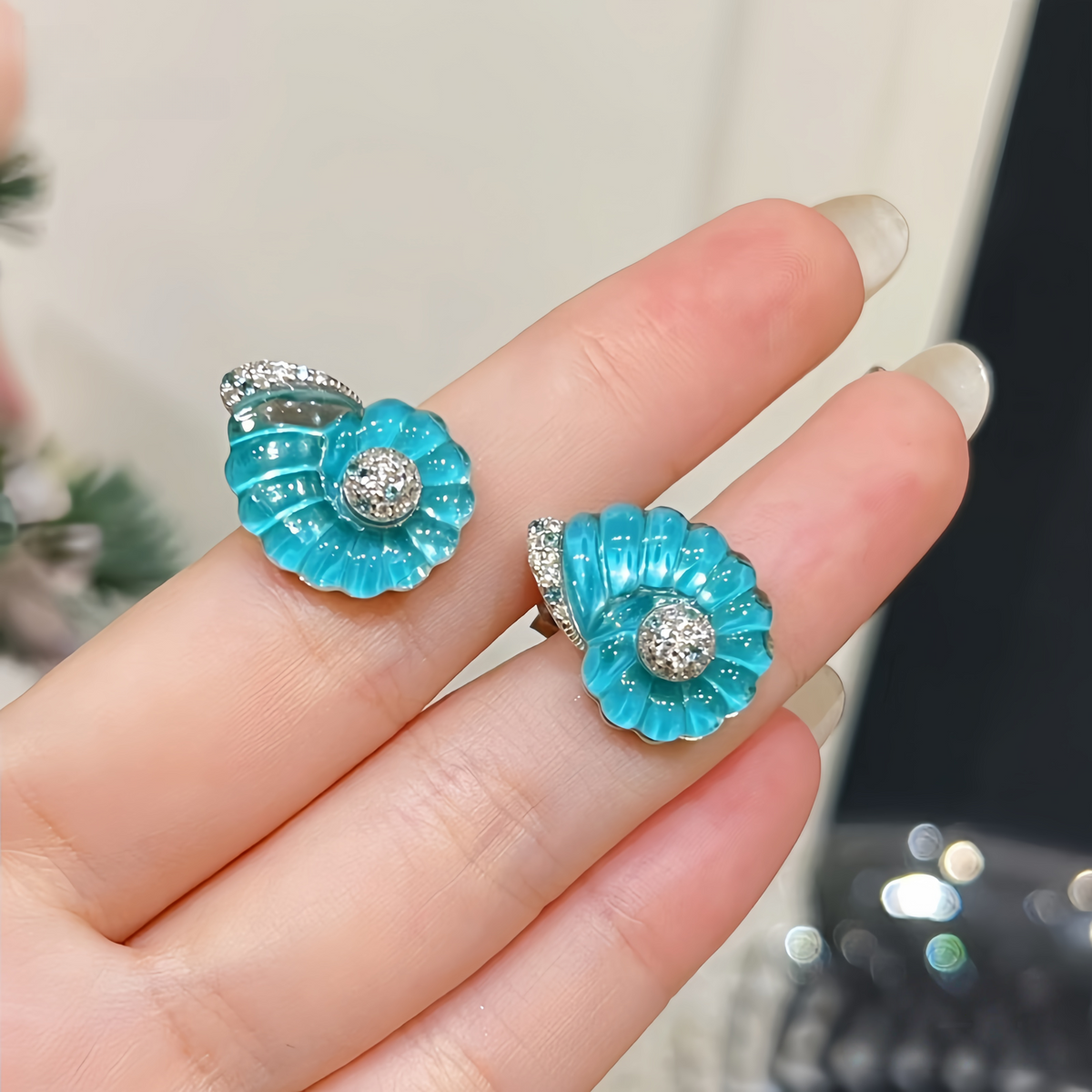 Rhodium-plated sterling silver nautilus shell stud earrings with blue cubic zirconia and clear pavé accents