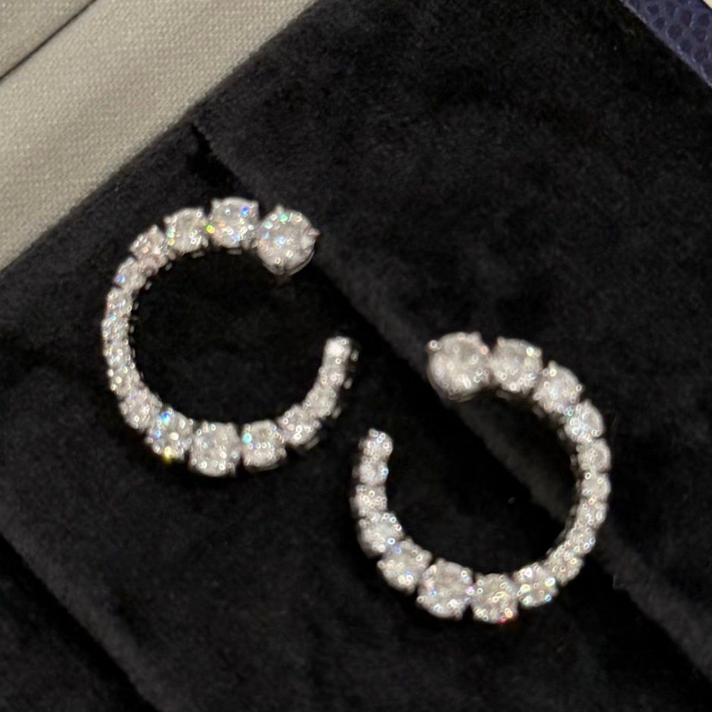 Rhodium-plated sterling silver C-shaped stud earrings with graduated round cubic zirconia and butterfly backs