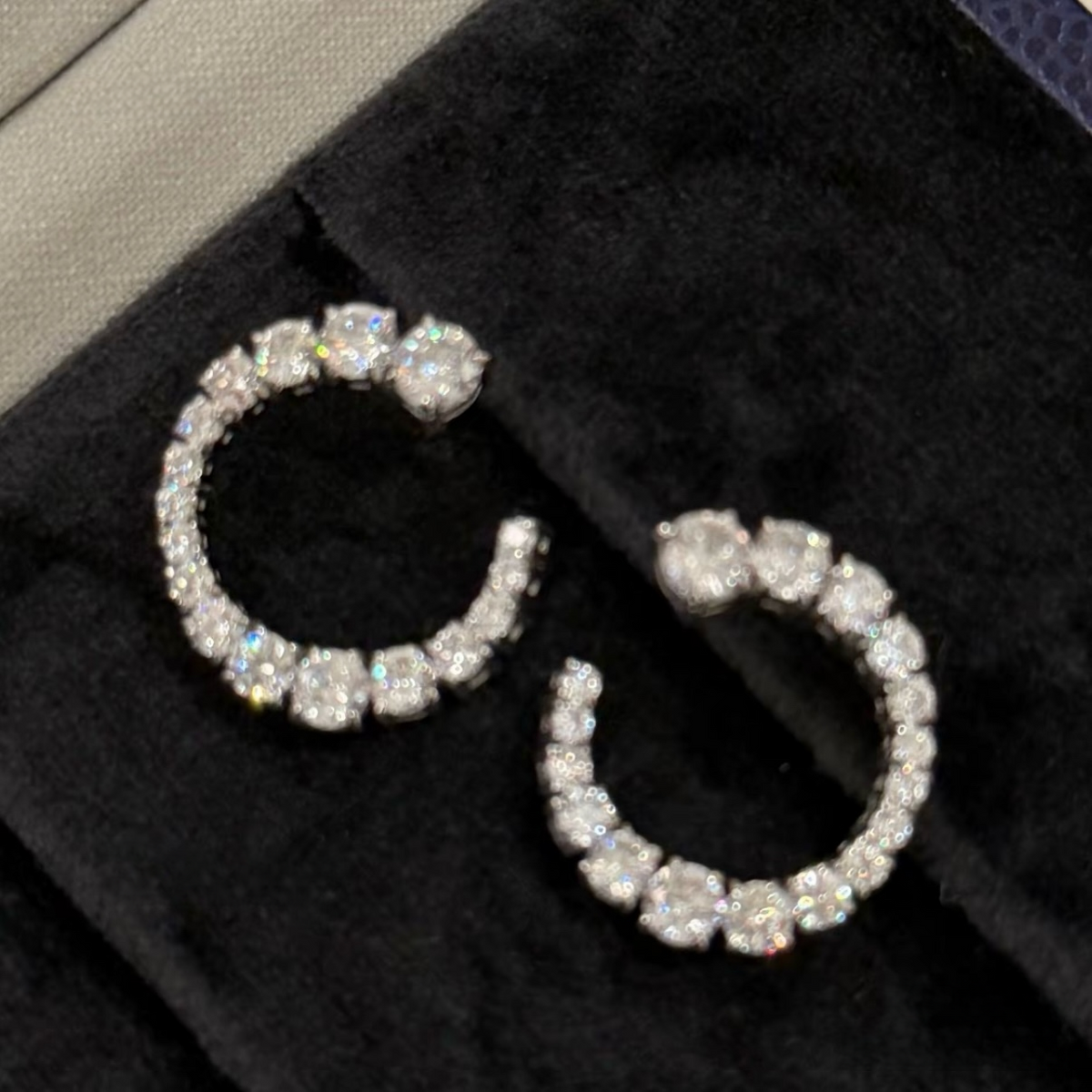Rhodium-plated sterling silver C-shaped stud earrings with graduated round cubic zirconia and butterfly backs