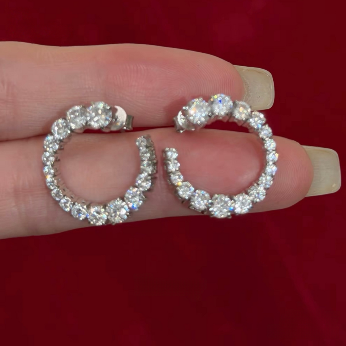 Rhodium-plated sterling silver C-shaped stud earrings with graduated round cubic zirconia and butterfly backs