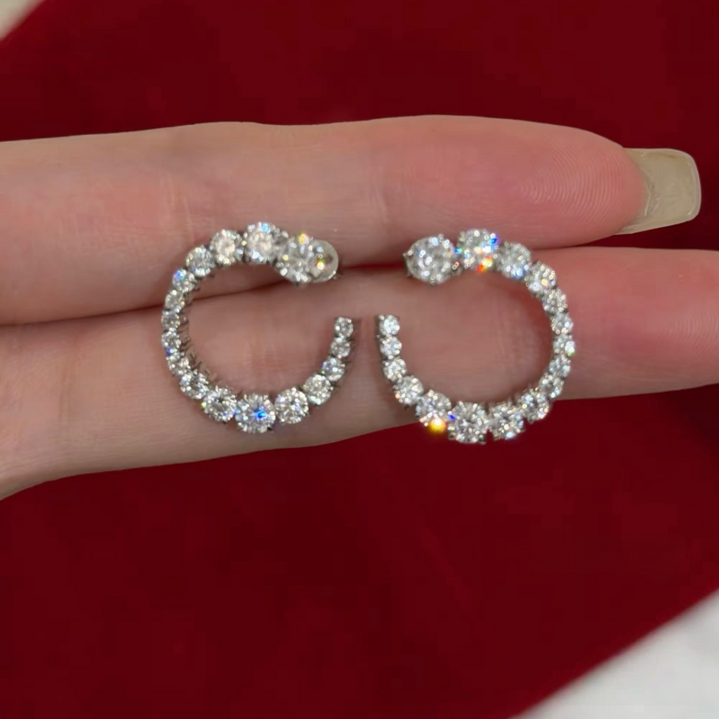 Rhodium-plated sterling silver C-shaped stud earrings with graduated round cubic zirconia and butterfly backs