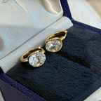 Gold and silver sterling silver huggie earrings with a suspended clear cushion-cut cubic zirconia stone