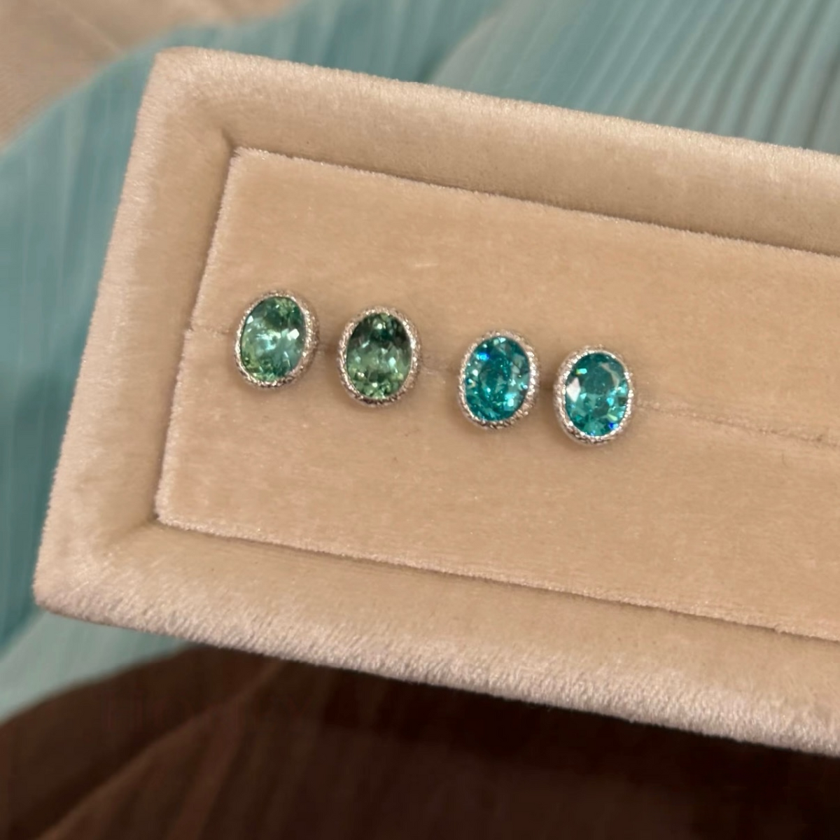 925 sterling silver oval synthetic YAG stud earrings in Paraiba blue and mint green with cubic zirconia halo surrounds and butterfly backs