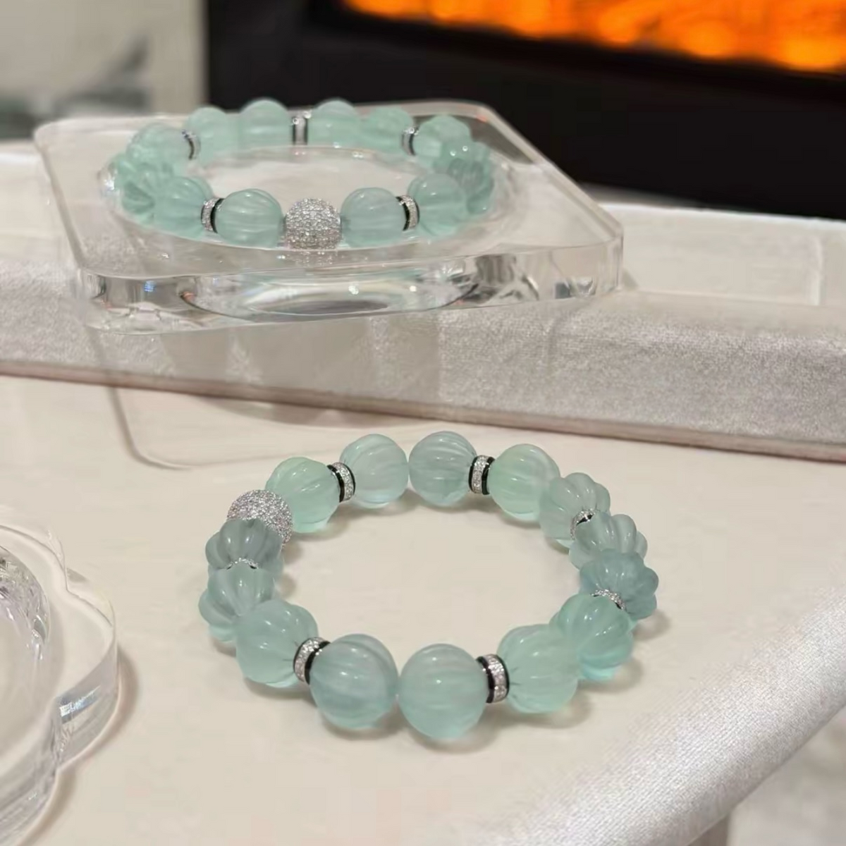 Pale mint-blue natural fluorite bracelet with carved pumpkin beads, transparent spacer elements, sterling silver decorative rings, and sparkling accent bead