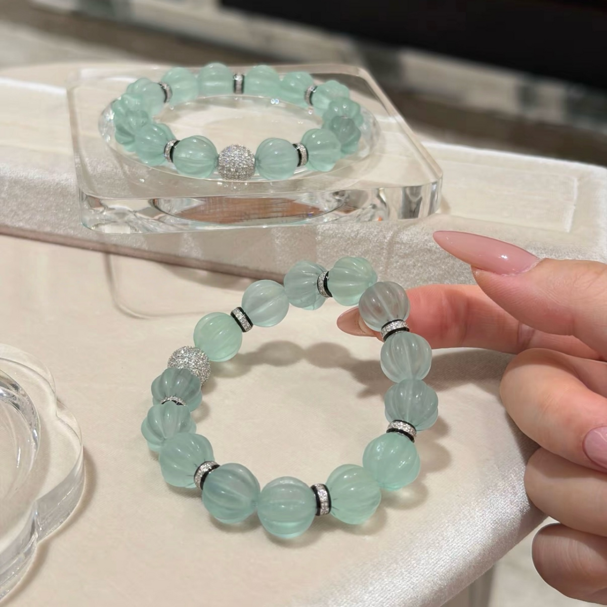 Pale mint-blue natural fluorite bracelet with carved pumpkin beads, transparent spacer elements, sterling silver decorative rings, and sparkling accent bead