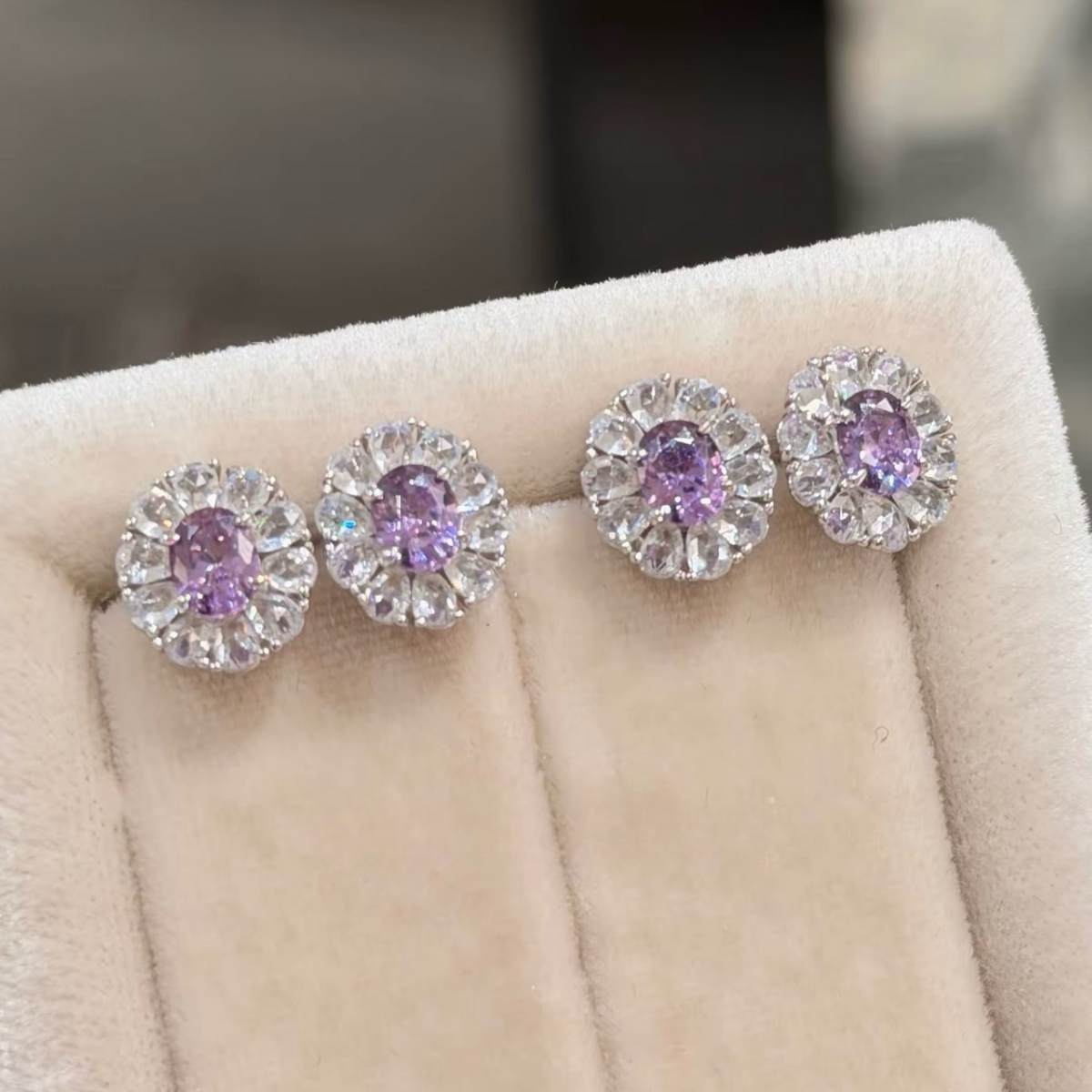 Sterling silver stud earrings with green and purple oval cubic zirconia center stones surrounded by clear sparkling halos
